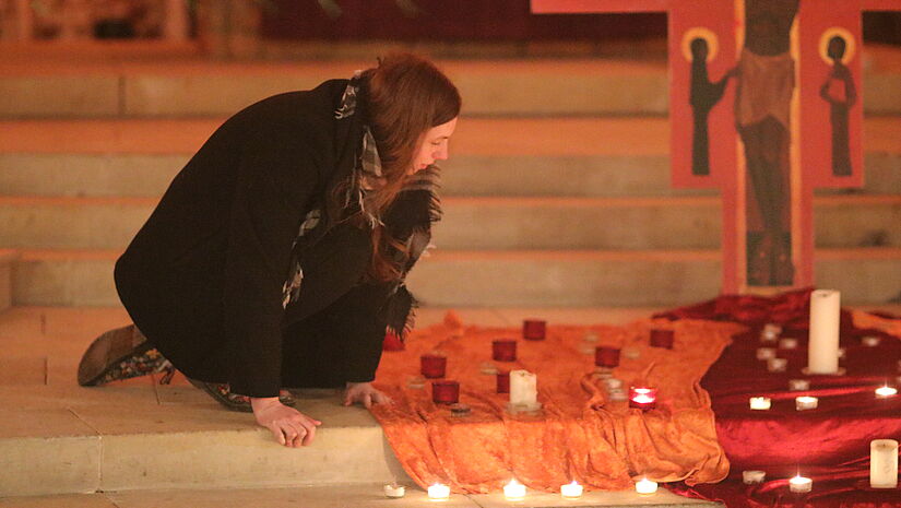Jugendliche bläst Kerzen beim Taizé-Gottesdienst aus 