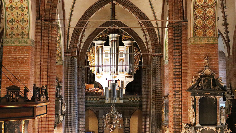 Draufsicht auf eine große prächtige Orgel, umgeben von gotischen Bögen