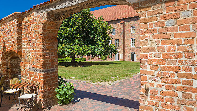 Kloster Cismar in Ostholstein Durch einen Torbogen aus gemauerten roten Ziegelsteingen geht man in den Innenhof des Klosters in Cismar.