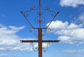 Gipfelkreuz auf dem Jungfernberg im Lieper Winkel auf Usedom vor blauem Himmel.