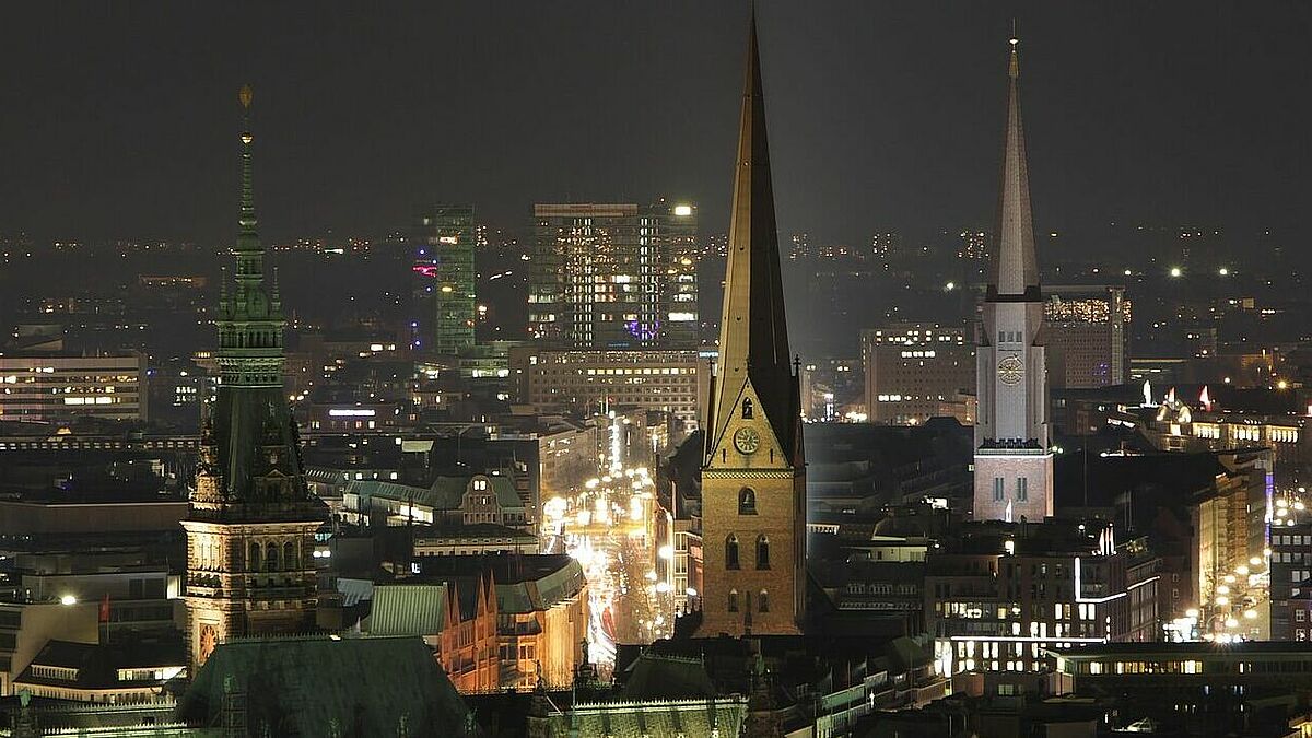 Blick bei Nacht auf die Hamburger Innenstadt mit Türmen vom Rathaus, der Petri- und Jacobikirche.