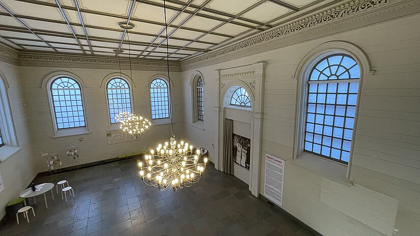 Ein Blick von oben in den leeren, weiß gestrichenen repräsentativen Betsaal der Synagoge in Rendsburg