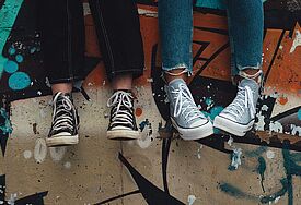 Zwei Paar Füße in Converse-Schnürschuhen