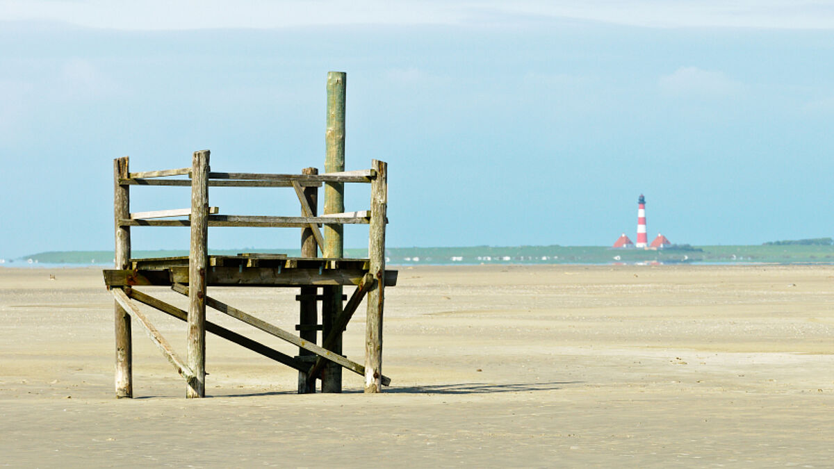 Strand bei St. Peter-Ording mit Leuchtturm Westerhever im Hintergrund.