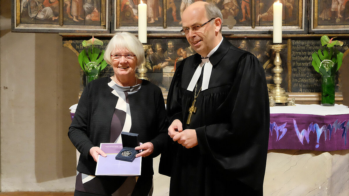 Stellvertretend für viele Ehrenamtliche in der Kirche und mit großer Dankbarkeit nimmt Ina Koppelin die Bugenhagenmedaille von Bischof Gothart Magaard entgegen.