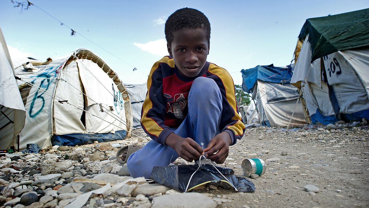 Zwei Jahre nach dem verheerenden Erdbeben in Haiti repariert ein Junge seinen selbstgebauten Drachen - ein wenig Normalität im Chaos. Hurrikan Sandy hat jetzt wieder Opfer in dem traumatisierten Land gefordert 