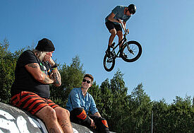 Mit einem Besuch im Skate- und BMX-Park "Sportpiraten" hat die Präses der Synode der Evangelischen Kirche in Deutschland (EKD), Anna-Nicole Heinrich (re.), am Montag ihre Erkundungstour durch Deutschland begonnen. Heinrich sprach mit dem Gründer des Vereins, Dirk Dillmann (li.), und Teamern.