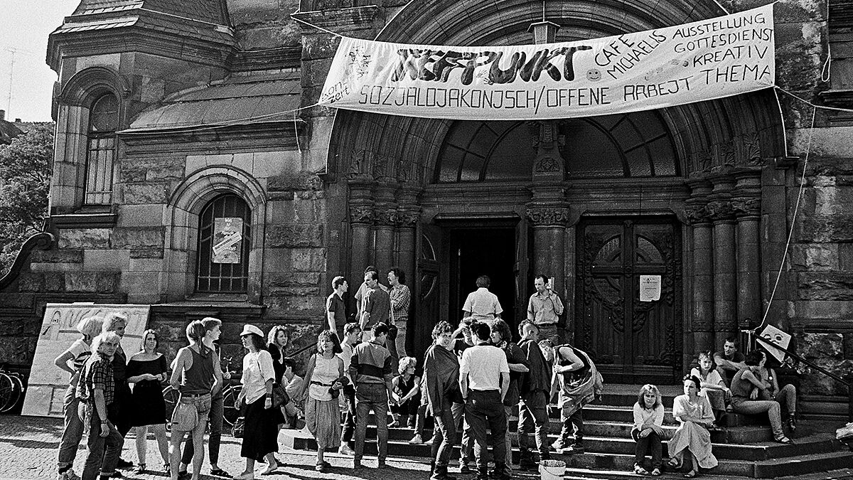 Ein Kirchentag der Evangelisch-Lutherischen Landeskirche Sachsens fand vom 06.-09.07.1989 in Leipzig statt. Das Motto des Kirchentags war: "Was ist der Mensch, dass du seiner gedenkst?" Foto: Vor der Michaeliskirche in Leipzig, Treffpunkt "Sozialdiakonisch/Offene Arbeit", Cafe Michaelis, Ausstellung, Gottesdienst - eine Initiative parallel zum Kichentag.