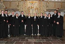 Hier kommen die Neuen! Die Pastorinnen und Pastoren stehen im Talar zusammen mit Bischof Magaard in der Christkirche