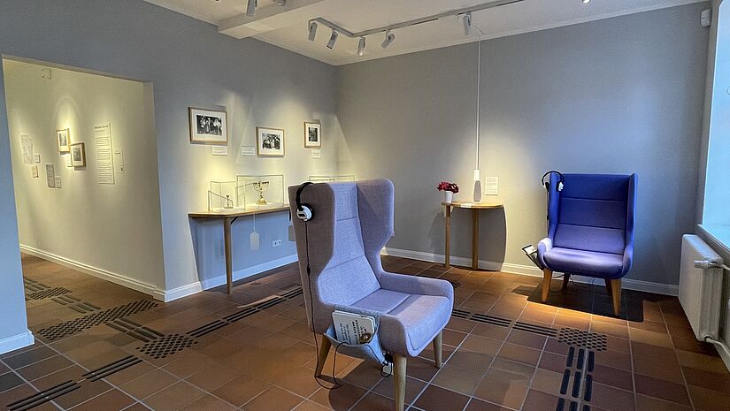Ein wohnlich eingerichteter Raum mit Sesseln und Ausstellungsstücken im Jüdischen Museum in Rendsburg