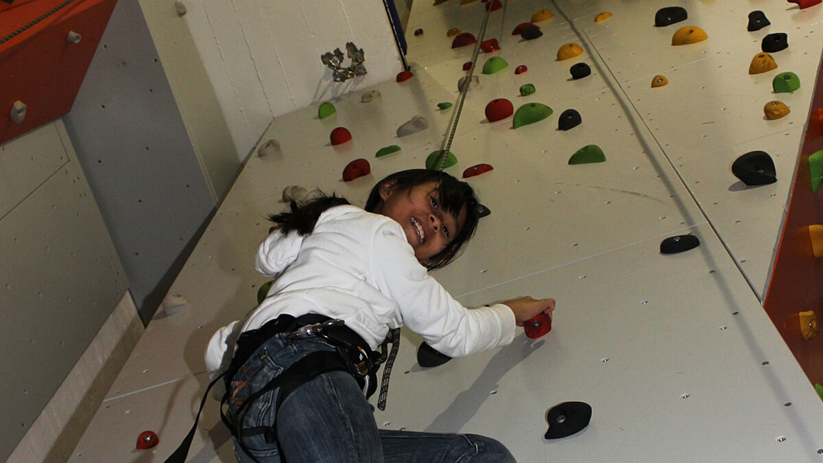 Jessica klettert die Wand des Kirchturms hoch – mit einem Seil gut gesichert