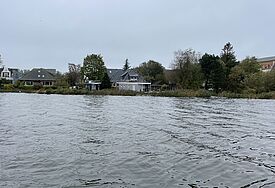 Blick über eine Wasserfläche mit zwei angetriebenen Hausbooten bei der Überschwemmung 2023