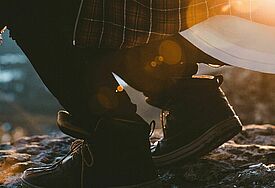 Hockender Mensch im Sonnenaufgang