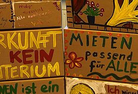 Mit bemalten Umzugskartons werben die Menschen für bezahlbaren Wohnraum
