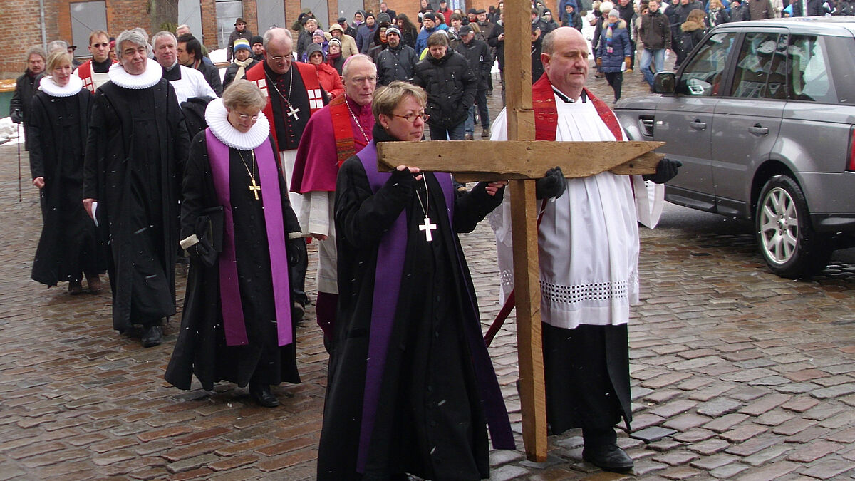 Die evangelische Pröpstin Petra Kallies und der katholische Dechant Joachim Kirchhof trugen das schwere Holzkreuz beim Kreuzweg durch Lübecks Altstadt zur zweiten Station. 