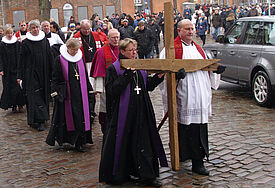 Die evangelische Pröpstin Petra Kallies und der katholische Dechant Joachim Kirchhof trugen das schwere Holzkreuz beim Kreuzweg durch Lübecks Altstadt zur zweiten Station.