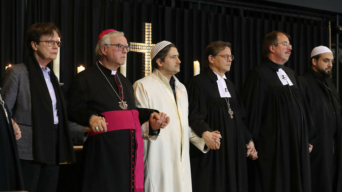 Generalsuperintendentin Ulrike Trautwein (l-r), der Berliner Erzbischof Heiner Koch, der Berliner Imam Kadir Sanci, der evangelische Berliner Bischof Markus Droege, der Pfarrer der Gedaechtniskirche, Martin Germer, und der Berliner Imam Ferid Heider reichen sich die Haende am Dienstagabend (20.12.2016) in der Berliner Kaiser-Wilhelm-Gedaechtniskirche bei einem Trauergottesdienst fuer die Opfer des Anschlags auf einen Berliner Weihnachtsmarktes. Bei dem Anschlag war ein Unbekannter am Montagabend mit einem Lastwagen auf einen Weihnachtsmarkt an der Gedaechtniskirche gefahren. Mindestens zwoelf Menschen wurden getoetet und rund 50 verletzt. (Siehe epd-Meldung vom 20.12.16)