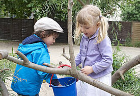 Kinder spielen im Garten einer Kindertagesstätte.