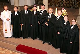Bischof Magaard (Mitte) und Archdeacon Dr. Alex Hughes aus der Diözese Ely (links) mit den sieben ordinierten Pastorinnen und Pastoren