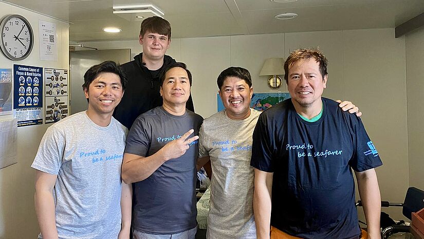 Seeleute in der Seemannsmission Brunsbüttel mit T-Shirts zum "Internationalen Tag der Seeleute" 2024.