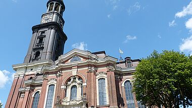 Kirche von unten mit einem Weitwinkel fotografiert, blauer Himmel mit Wolken