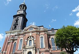 Kirche von unten mit einem Weitwinkel fotografiert, blauer Himmel mit Wolken