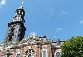 Kirche von unten mit einem Weitwinkel fotografiert, blauer Himmel mit Wolken