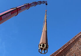 Sanierter Kirchenturm wird auf das Dach der St. Nicolai Kirche in Eckernförde gezogen