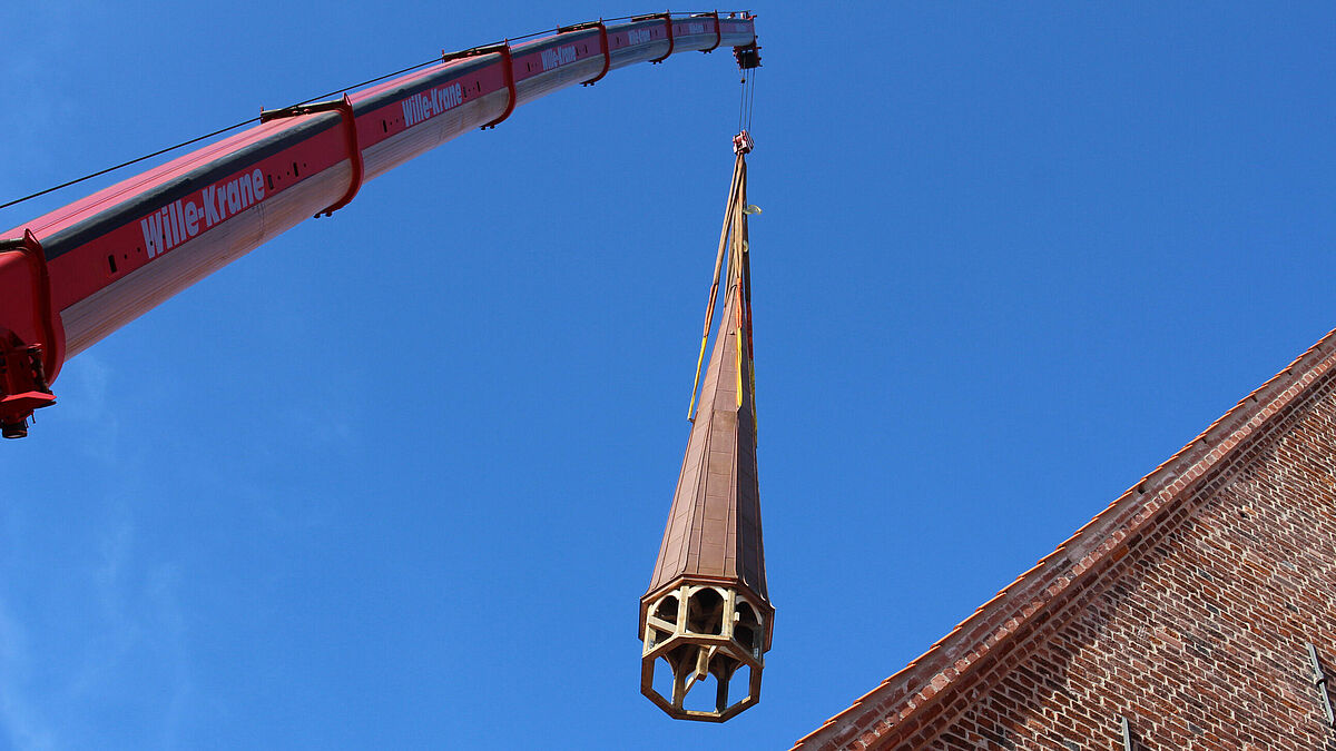 Sanierter Kirchenturm wird auf das Dach der St. Nicolai Kirche in Eckernförde gezogen