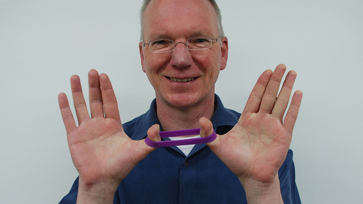 Der Flensburger Pastor Klaus Guhl will aktiv gegen alltägliches Gemecker, Gemotze und Gejammer vorgehen - mit einem lila Armband.