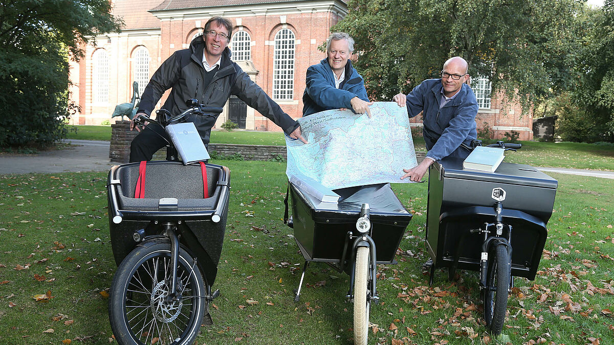 Die drei Hamburger Pröpste Thomas Drope Karl-Heinrich Melzer und Frie Bräsen (von links) fahren am Reformationstag auf Lastenfahrrädern rund 80 Altarbibeln im Kirchenkreis Hamburg-West/Südholstein aus. Einige Tage zuvor hatten sie sich zur Planung an der Trinitatis Kirche Hamburg Altona getroffen. 