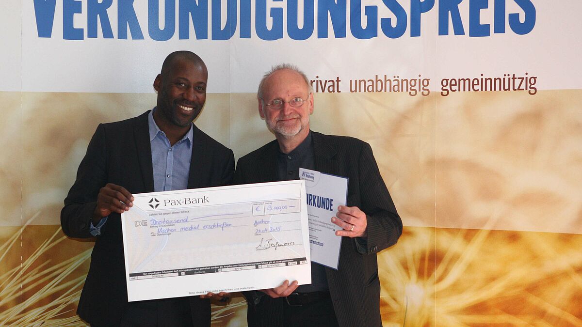 Klaus-Uwe Nommensen (r.), Referent für Öffentlichkeitsarbeit im Kirchenkreis Nordfriesland, nahm stellvertretend für die Nordkirche den Verkündigungspreis von Laudator Joe Chialo entgegen