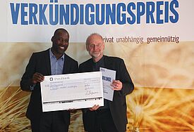 Joe Chialo (links) ist Manager der Shanty-Rockband „Santiano“. In Aachen überreichte der gläubige Christ am 24. April den zweiten Platz des Verkündigungspreises 2015 an Klaus-Uwe Nommensen, der stellvertretend für die Nordkirche vor Ort war