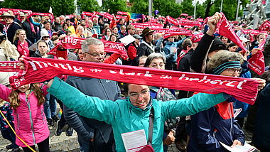Perfekte Stimmung bei der Abschlussfeier des Kirchentags in Hannover. Menschen halten Banner mit dem Motto "mutig, stark, beherzt".