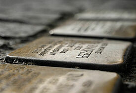 In eine Kopfsteinpflasterstraße eingelassen Stolpersteine. 