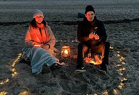 Strandszene aus dem Video "Zündkerzen", Mann und FRau sitzen in der Dunkelheit am Strand