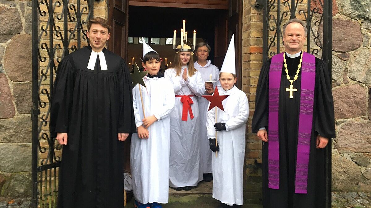 Eine Liebeserklärung an die Dorfkirche Steinmocker machten v.l. Pastor Helge Jörgensen, die Luciasängerinnen und - sänger der Opernale und Bischof Tilman Jeremias