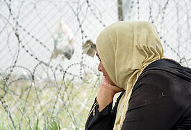 Eine Frau aus dem Irak sitzt am Grenzzaun im Flüchtlingslager in Idomeni (Griechenland, Archiv)