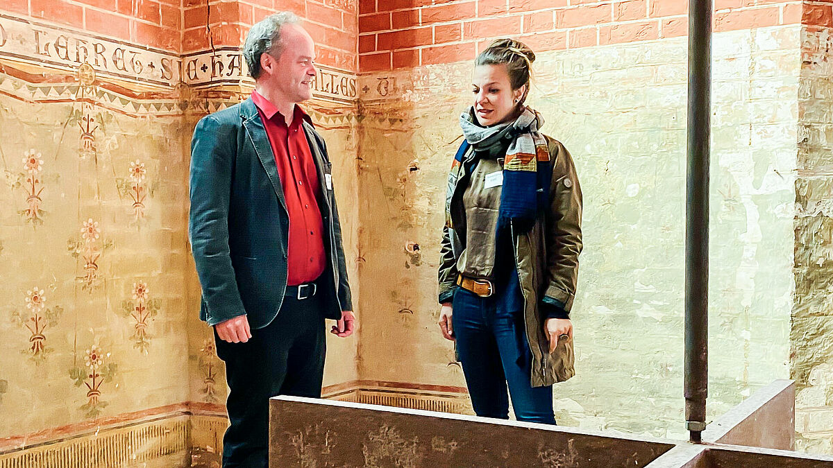 Bischof Tilman Jeremias und Anna Luise Klafs vor dem Kunstwerk „Stigma“ des 2021 verstorbenen Bildhauers Wieland Schmiedel (ein Mahn- und Gedenkzeichen an die Judenverbrennung und Vertreibung 1492 in Sternberg).
