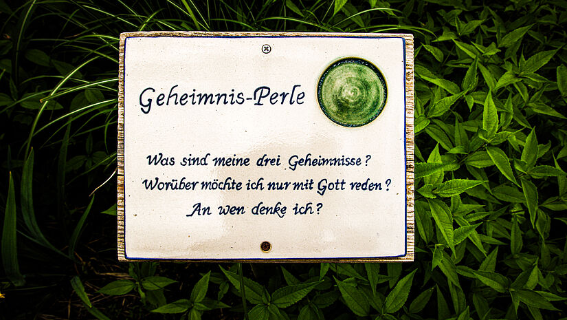 Eine Tafel im garten inspiriert zum Nachdenken über sich selbst. Die grüne Geheimnisperle fragt nach drei Geheimnissen und worüber ich nur mit Gott reden möchte.