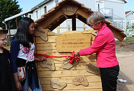 Die beiden Kinderbischöfe Felix und Zoe schneiden mit ihrer großen Kollegin Kirsten Fehrs symbolisch ein rotes Band durch