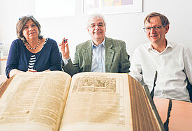 Von einer alten Schrift bis hin zum Mikrochip: Pröpstin Carmen Rahlf (v.l.), Dr. Heinz Peter Mauelshagen und Wolfgang Schmutz präsentieren eine Bibelausstellung in Flensburg.