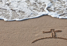 Kreuz im Sand, Symbolbild.