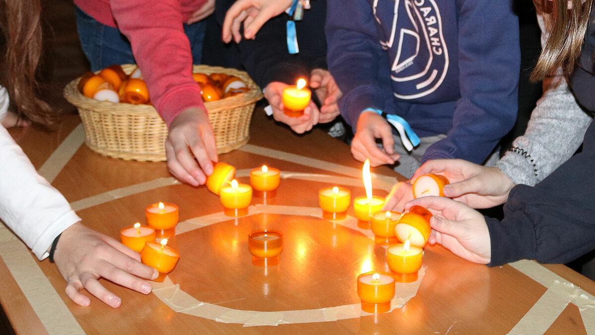 Jugendliche beim Entzünden von Kerzen