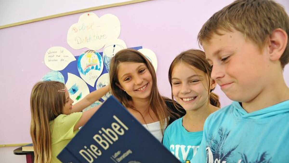 393990 Schüler einer Evangelischen Schule schauen gemeinsam in die Bibel (c) epd-bild