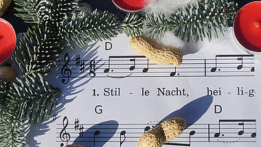 Ein weihnachtlich dekoriertes Liedblatt.