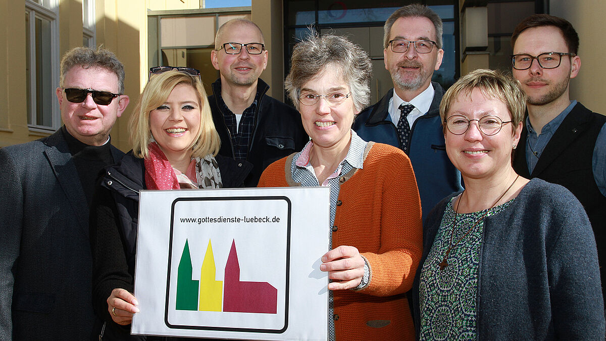 Sie zeichnen sich für die neuen Schilder verantwortlich: Michael Murzin (Freie Evangelische Gemeinde, hinten v.l.), Volkmar Glöckner (Evangelisch-Freikirchliche Gemeinde - Baptisten), Björn Schneidereit (Ev.-Luth. Kirche St. Thomas); Christoph Giering und Martina Altendorf (Römisch-Katholische Kirche, vorn v. l.), Imke Akkermann-Dorn (Ev.-Reformierte Kirche) und Pröpstin Petra Kallies (Ev.-Luth. Kirchenkreis Lübeck-Lauenburg).
