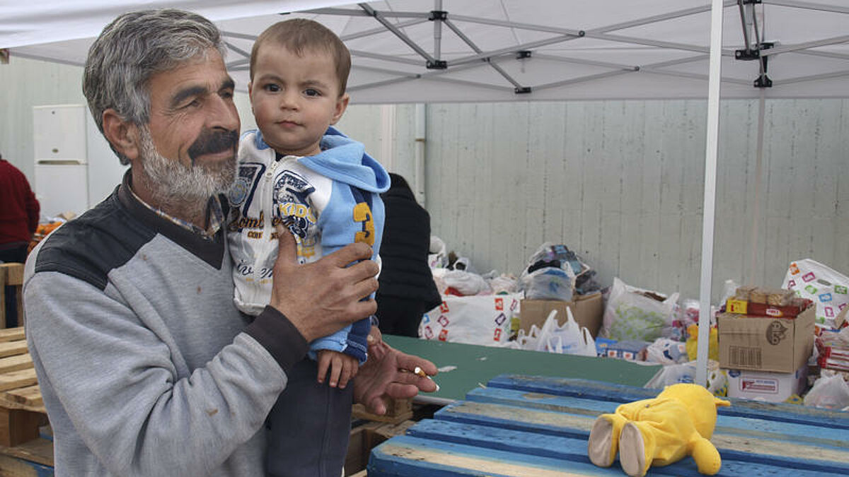 Badran, ein Flüchtling aus Syrien, Anfang März mit seinem Enkel Orhan in einem provisorischen Flüchtlingslager im Hafen von Piräus bei Athen