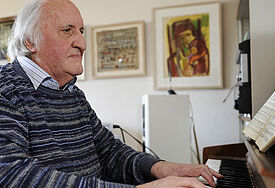 Der Kirchenmusiker Martin Gotthard Schneider an seinem heimischen Klavier. Das Foto zeigt ihn im April 2010 in seiner Wohnung in Freiburg