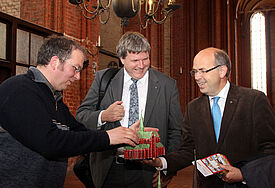 Kantor Martin Poley (St. Nikolai Wismar) zeigt Bischof Dr. Andreas von Maltzahn und Bischofsvertreter Gothard Magaard ein Kirchenmodell zum Anfassen